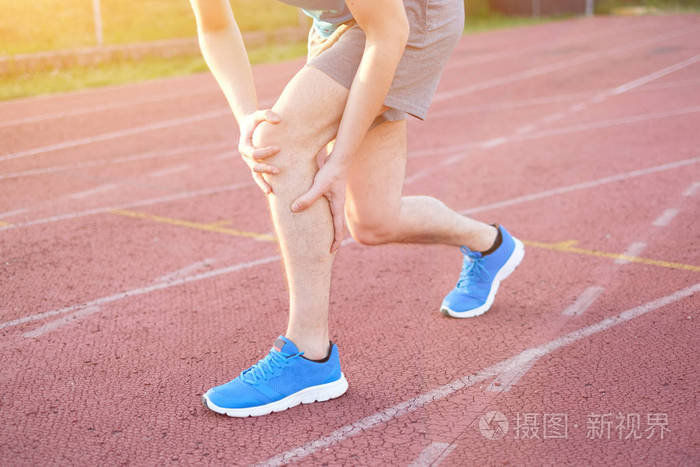 跑步的运动员感觉疼痛,因为受伤的膝盖
