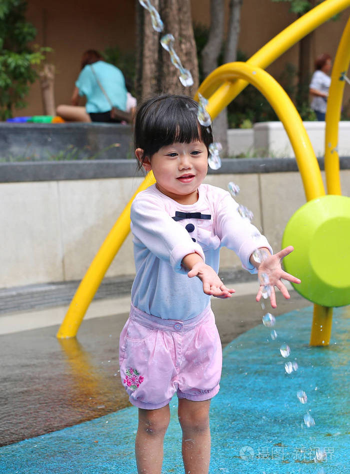 孩子玩玩水公园喷泉中的小女孩