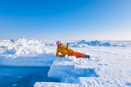 在黄色向红头发美丽背景下营 Barneo 在冰天雪地的北方的白霜的小伙子的头发极冬季夹克粉色针织帽下的女孩