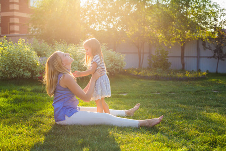 快乐家庭母亲和女儿拥抱在夏天的性质
