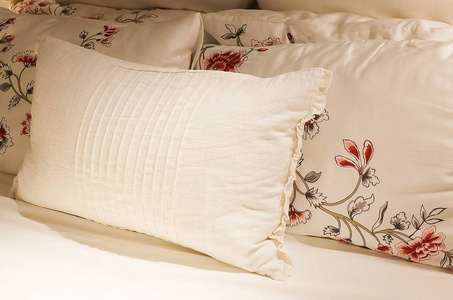 白色舒适床上的复古枕头