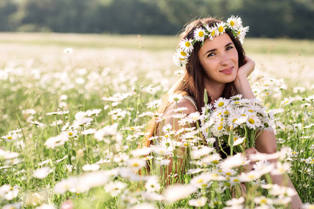 美丽的女人享受黛西场 漂亮的女性，躺在草地上的花朵，漂亮的姑娘，放松户外，有乐趣，抱着植物 快乐的年轻女人和春绿色自然，和谐