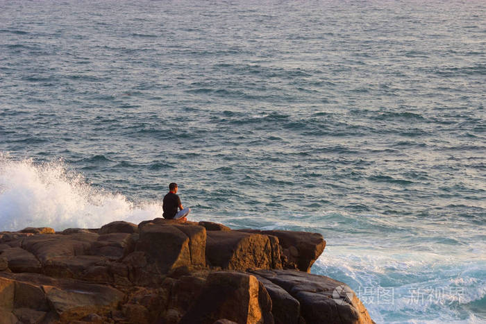 冥想在海边岩石上的人