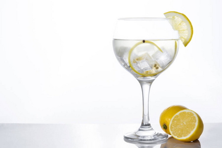 Glass 的杜松子酒补加柠檬白色背景上