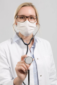 年轻的女医生用听诊器和医疗面罩