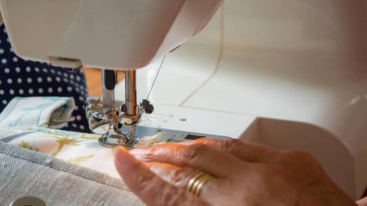 女手使用缝纫机缝织物