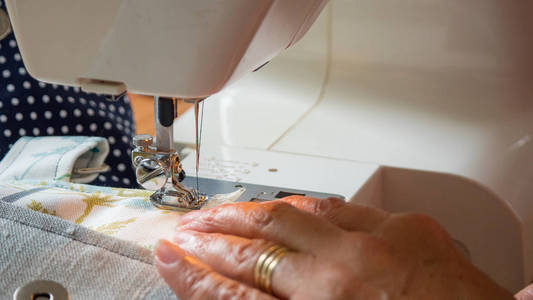 女手使用缝纫机缝织物