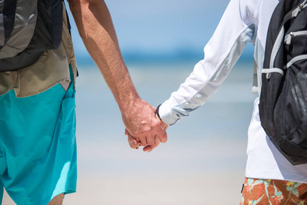 年轻夫妇手牵着手去海滩