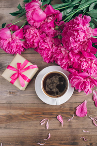 一杯咖啡 粉红牡丹图案及礼品盒木制背景上。早上好。妇女或母亲节的背景