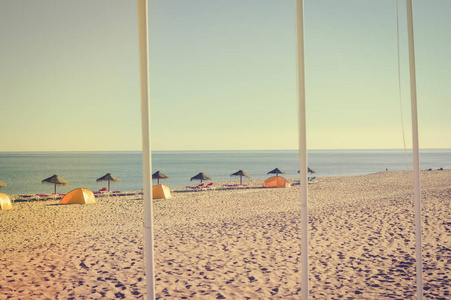 蓝色的天空和海滩伞椅子上美丽的热带海洋的海岸线，阳光明媚的户外风景背景