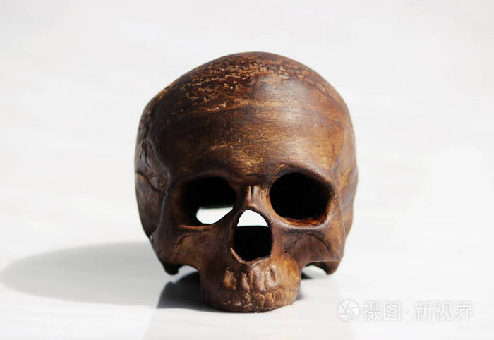 一个在白色背景上的烛台的形式的人类头骨模型
