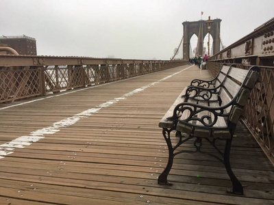 板凳在布鲁克林大桥和雾在人行道上