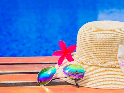 夏天的帽子与花在泳池边的太阳镜。假期和松弛，夏天旅游概念