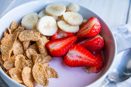 健康的早餐，其中包括玉米片，燕麦片，酸奶，香蕉和草莓