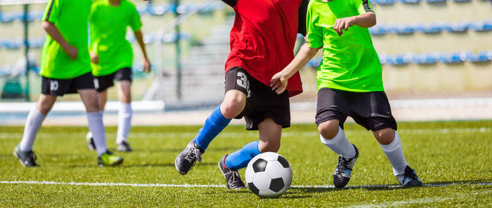 培训及足球比赛之间青年足球队。年轻的男孩玩足球游戏。运行和踢足球的球员之间的硬竞争。最后一场比赛的孩子们的足球比赛