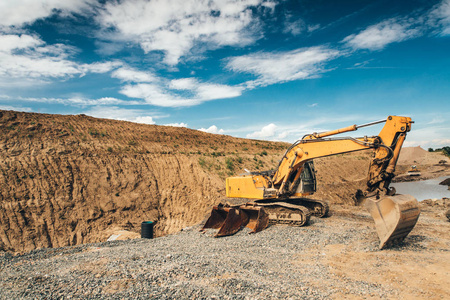 工业与重型勺移动地球和在道路工程在公路建设过程中加载泥头车挖掘机