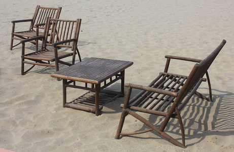 用木头在沙滩上做的椅子和桌子