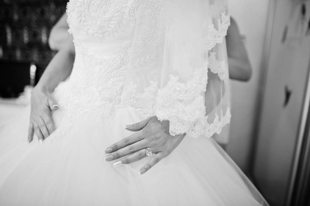 传说新娘抱着她精致的白色婚纱礼服。Bl