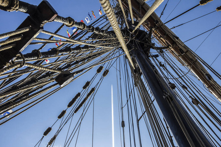 游艇的航海部分或大型旧帆船, 在蓝天前有绳索索具帆桅杆结信号旗