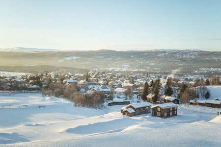 美丽的早晨日出与耀斑期间挪威小城的全景图和温暖的目光