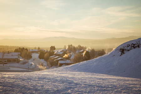 美丽的早晨日出与耀斑期间挪威小城的全景图和温暖的目光