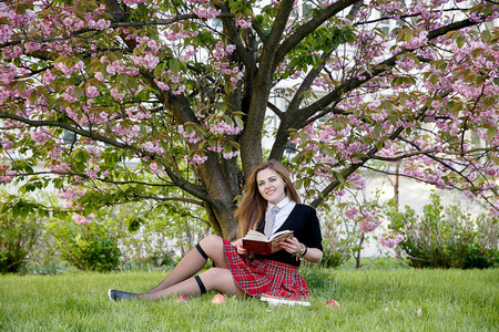 在公园学习，一个漂亮的女孩，读一本书，之间的断裂性质，学生，女生在学习讲座