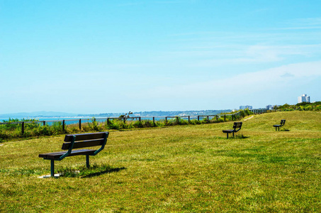 空板凳上海洋岸边，绿色植被茂盛的一座山