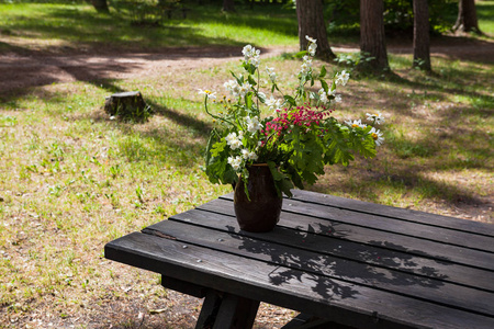 花瓶里的野花, 木桌上的花。夏季户外景观