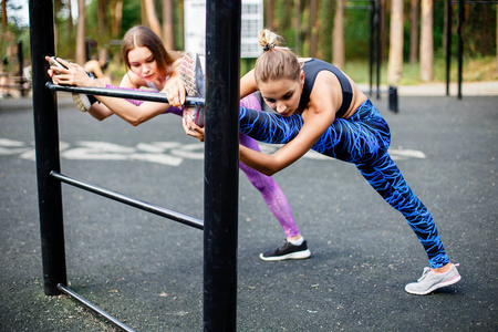 两个年轻的运动型女孩做伸展运动户外