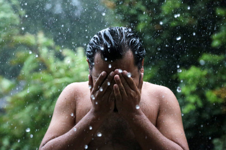 亚洲人用手拍了拍他面对在雨中。在下雨天的人