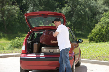 一个男人加载他的汽车行李箱图片