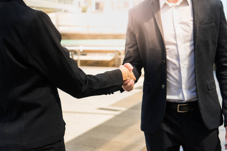 两个信心十足的商业人握手，证明他们的协议签署协议或他们的公司之间的合同  公司  企业。成功 处理 问候语和合作伙伴的概