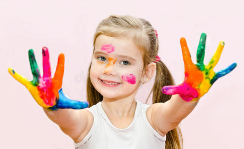 可爱的微笑小女孩手上涂着油漆