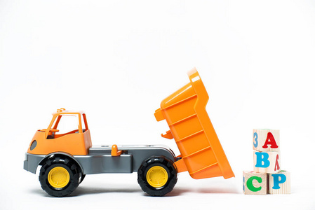 白色背景上的橙色的塑料玩具卡车