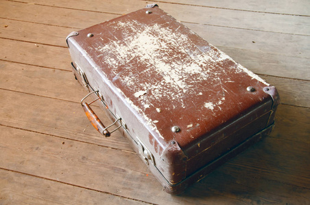 旧的棕色手提箱的木地板上