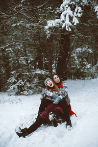 两个年轻的少女时髦女孩朋友在一起。关闭了的两个姐妹拥抱时尚肖像和最好的朋友开心，骑雪橇在冬季时间森林，穿着毛衣和围巾，夫妇供电系
