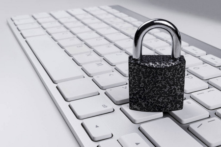 锁定的计算机免受或恶意软件的攻击。笔记本电脑被保护免受在线网络犯罪和窃听。计算机安全概念与键盘上的挂锁。保护各种风险