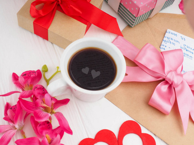 咖啡杯贴身粉色礼物信件和两颗心在杯子里浪漫爱情的概念