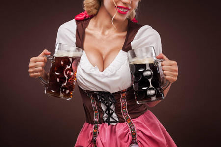 博伊德的特写肖像慕尼黑啤酒节的女孩女服务员，穿着传统的巴伐利亚服装，服务在黑色背景上的大啤酒杯