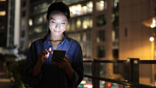 女人看着手机在晚上