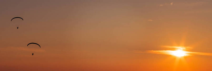 滑翔伞飞行在日落时分图片