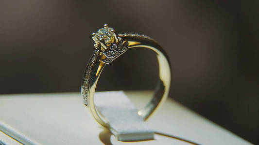 珍贵的钻石戒指。豪华的精品钻石珠宝橱窗与环的书呆子。与辉煌孤立在黑色背景上的金戒指