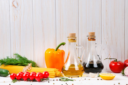 意大利面条 樱桃西红柿 橄榄油 药草和香料旧白色木制背景上。设置的健康食品。沙拉配料