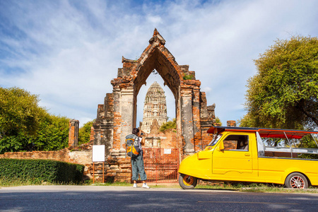 年轻的亚洲女性旅行者背包旅行与采取大城府，泰国玛哈泰寺背景的老式相机上的照片