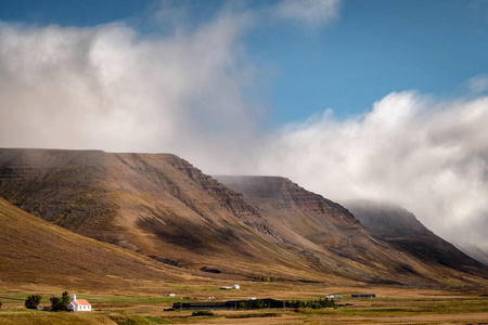 冰岛乡村景观的风景，在典型的小农场前面，戏剧性的冰岛景观。
