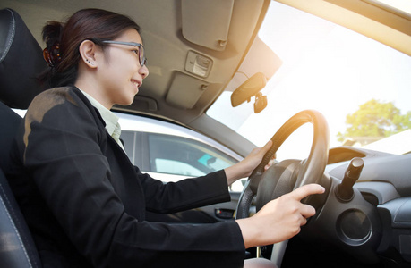 自信的亚洲业务女人驾驶一辆车图片