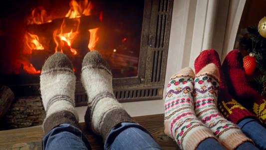 家庭在燃烧的壁炉庆祝圣诞节羊毛袜子