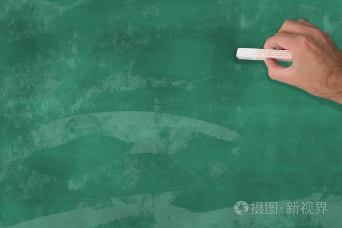手中拿着一支粉笔黑板前面有一空白