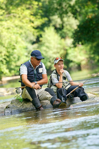 父亲和儿子在河边钓鱼图片