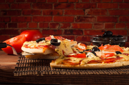 热比萨片用融化的奶酪仿古木制的桌子上